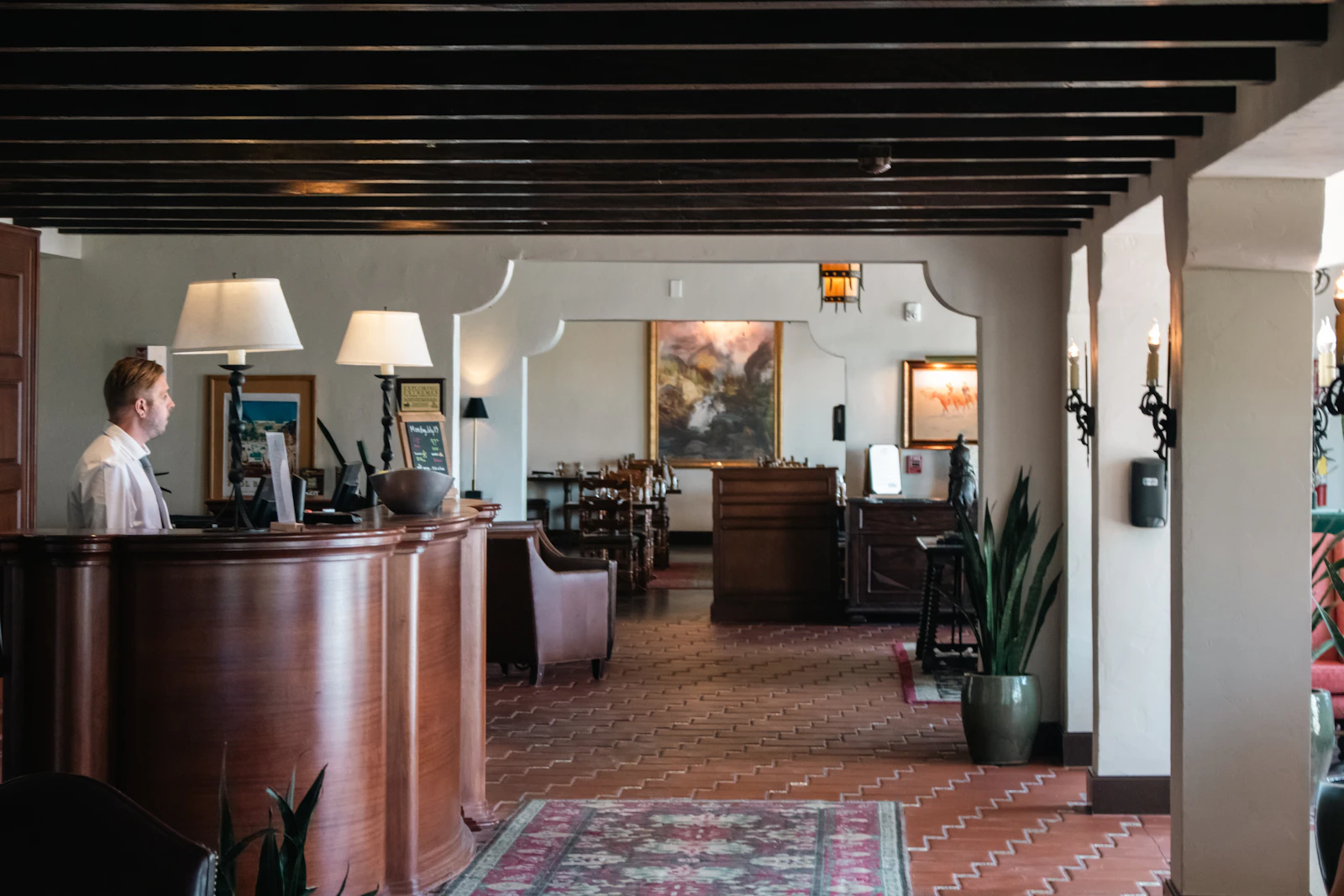 A hotel lobby with a reception desk and lounge chairs