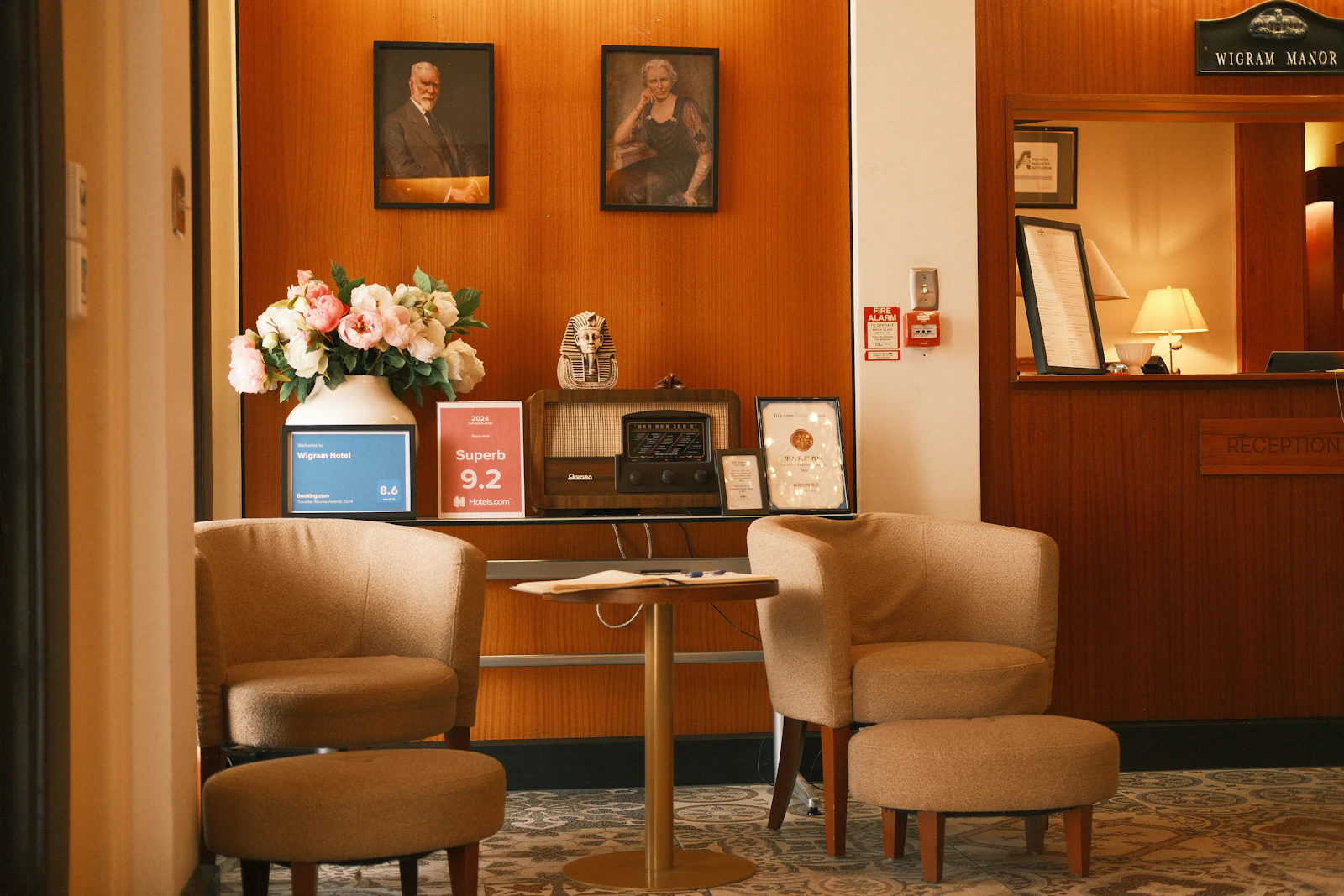 A warm hotel lobby corner with armchairs and a writing desk